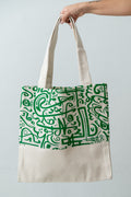 Green Calligraphy Tote – natural DAKK tote with a green Arabic calligraphy-inspired print, by Noha Fathy