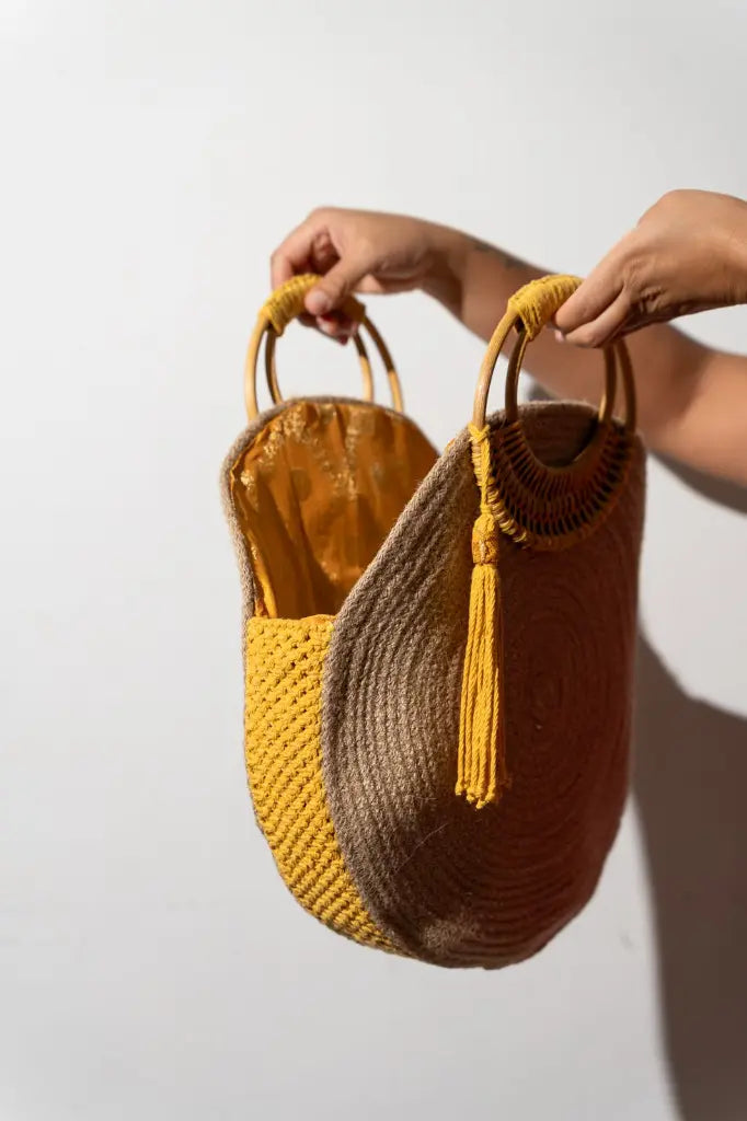The Soleil Bag – opened by its two bamboo handles to show the mustard interior, handmade by Noha Fathy